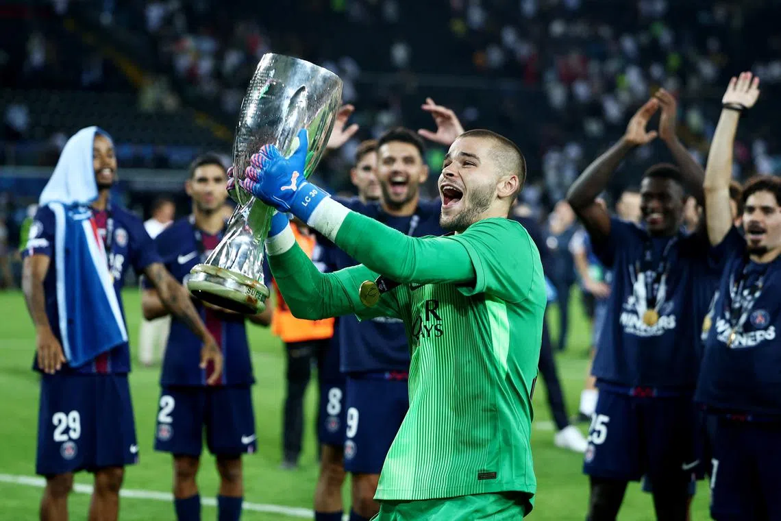 Soccer Football - UEFA Super Cup - Final - Paris St Germain v Tottenham Hotspur - Bluenergy Stadium, Udine, Italy - August 13, 2025 Paris Saint Germain's Lucas Chevalier celebrates with the trophy after winning the UEFA Super Cup REUTERS/Guglielmo Mangiapane