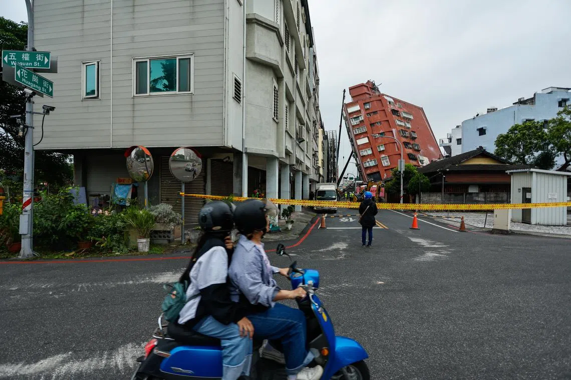 epa11261852 A motorcyclist with a passenger drives past the partially collapsed residential building Uranus, following the 03 April earthquake in Hualien, Taiwan, 06 April 2024. Although the government has been working to restore the city after the strongest earthquake in 25 years, the business and tourist sectors in Hualien have been affected, resulting in significant economic losses.  EPA-EFE/DANIEL CENG