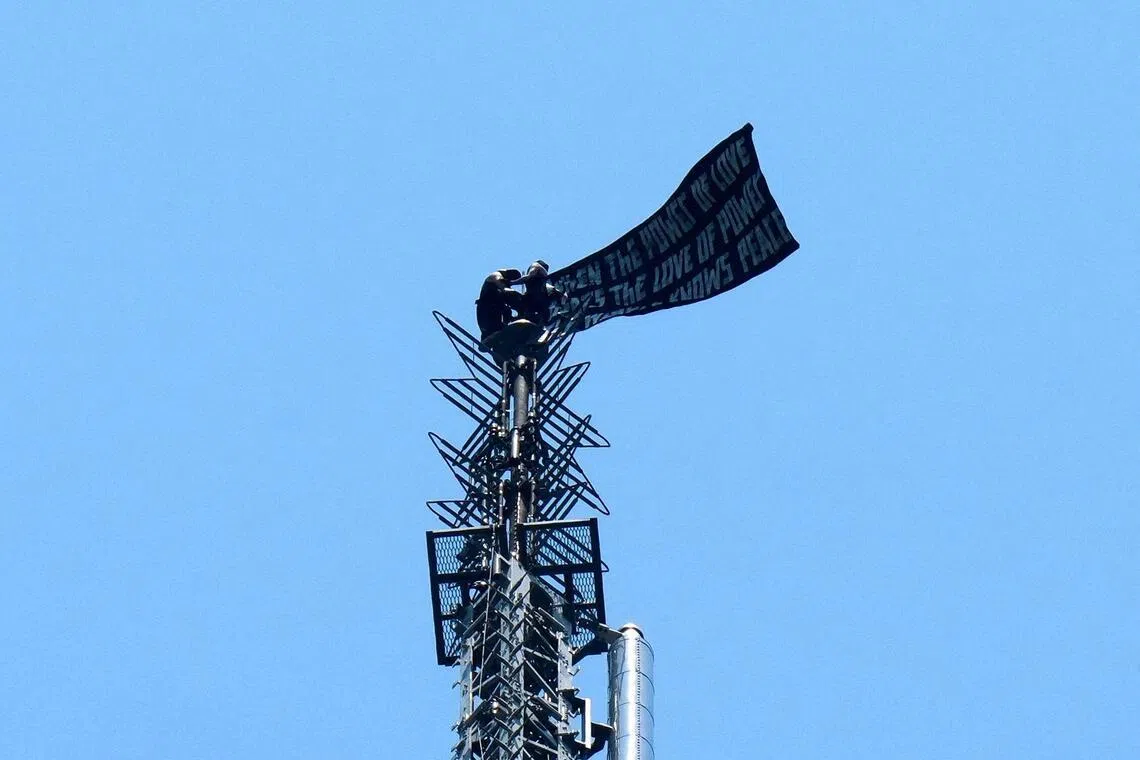 Two people display a banner atop the Empire State Building in the Manhattan borough of New York, U.S., July 1, 2026.  REUTERS/Adam Gray
