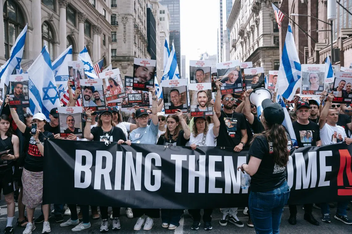 Protesters hold a 'Bring Them Home Now' banner during the annual Israel Day parade along Fifth Avenue in New York on June 2