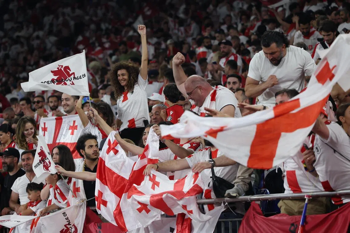 Supporters of Georgia celebrate after winning the Euro 2024 match against Portugal.