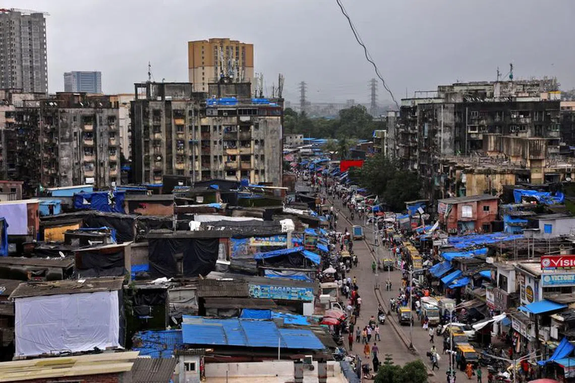 People and vehicles move past shanties in Dharavi, one of Asia's largest slums, in Mumbai, India, August 1, 2023. REUTERS/Niharika Kulkarni/File Photo