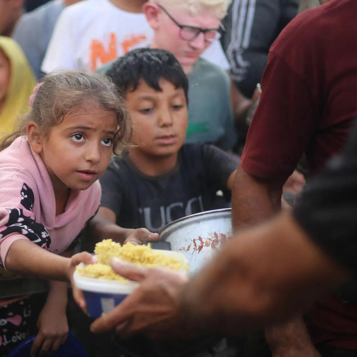Palestinians at a charity kitchen in the Nuseirat refugee camp, in the central Gaza Strip, on Oct 21.