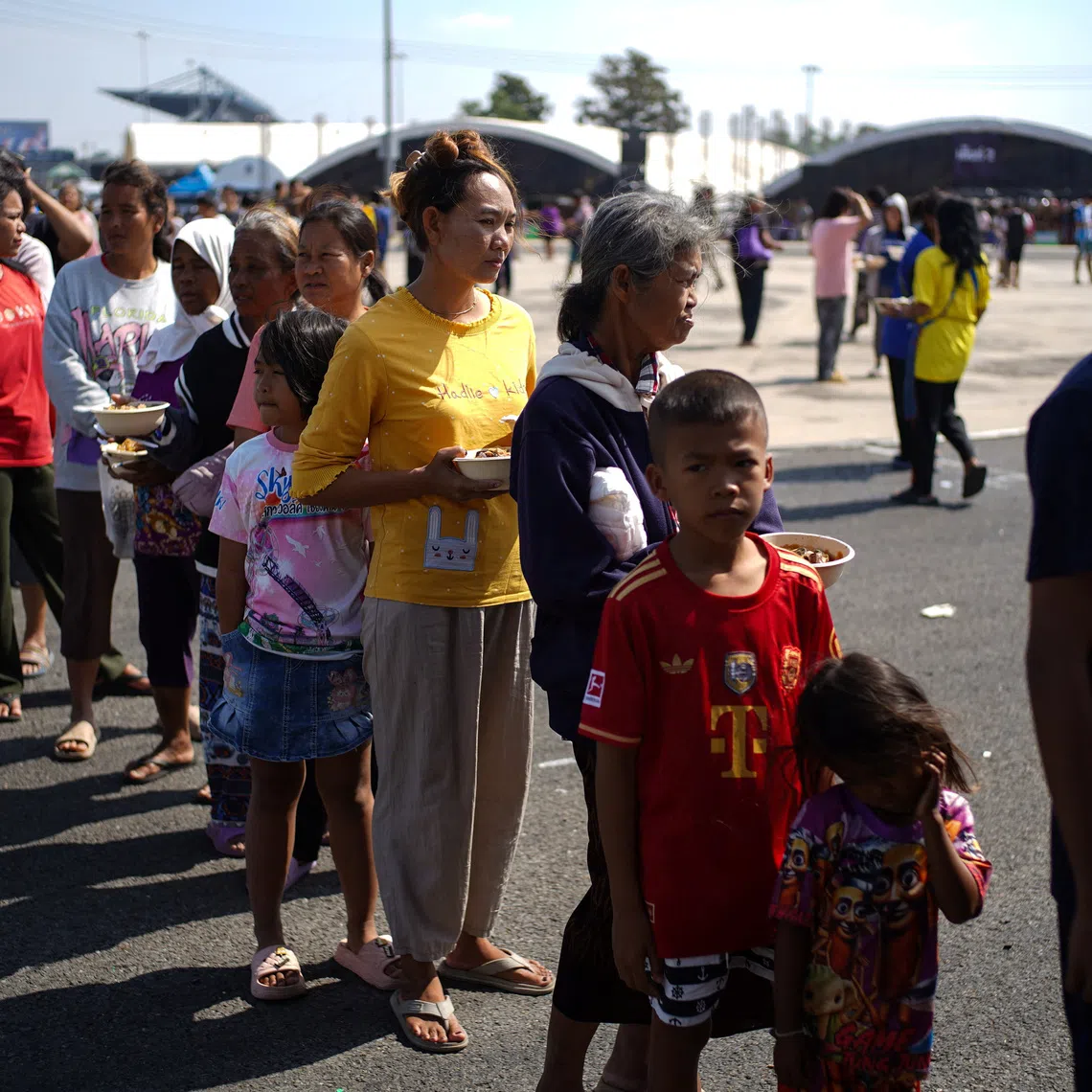 Displaced people queue for food at a temporary shelter amid deadly clashes between Thailand and Cambodia along a disputed border area, in Buriram province, Thailand, December 9, 2025. REUTERS/Athit Perawongmetha