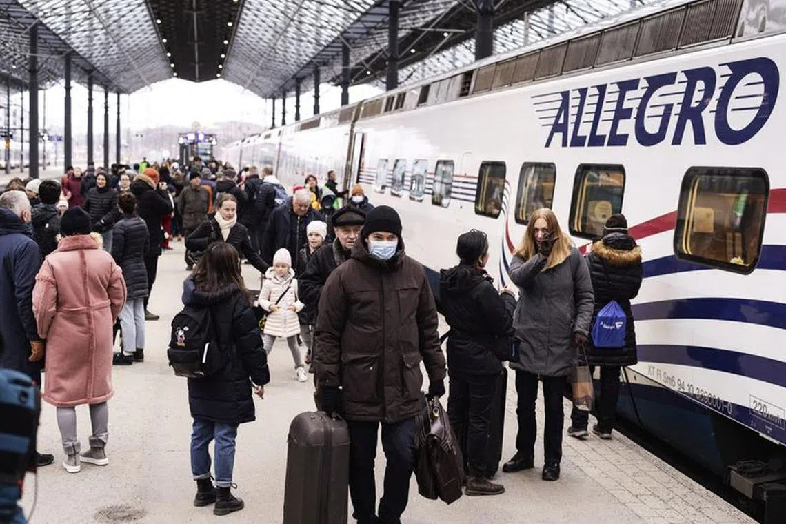 FILE PHOTO: Passengers of an Allegro train from St Petersburg, Russia, walk at the railway station on Sunday afternoon in Helsinki, Finland March 27, 2022. Allegro train service between Helsinki and St Petersburg will be temporarily discontinued from Monday, March 28, in light of sanctions imposed on Russia after its invasion of Ukraine. Lehtikuva/Roni Rekomaa via REUTERS ATTENTION EDITORS - THIS IMAGE HAS BEEN PROVIDED BY A THIRD PARTY. FINLAND OUT. NO THIRD PARTY SALES./File Photo