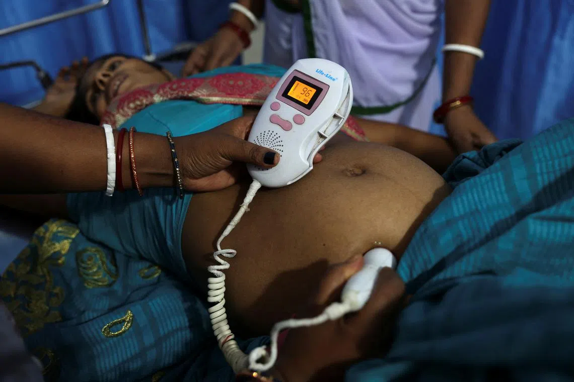 Zamerun Nisha, 33, lying down as a doctor checks the heartbeat of her child with an ultrasound machine, at the labour ward of a community health centre  on March 21.