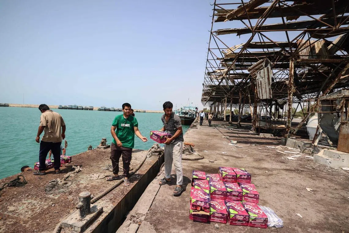 Iranian men off load food stuff close to the port’s damaged storage and warehousing facilities following a US military strike earlier in the week on Kuhestak, Sirik County, in Iran’s southern Hormozgan province on Sept 6.