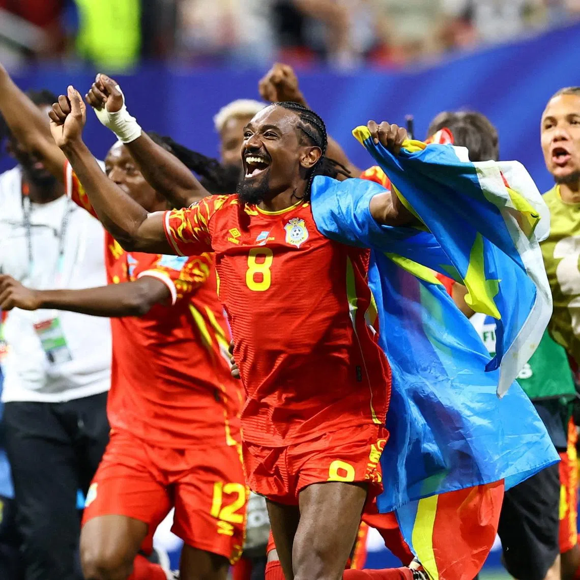 Soccer Football - FIFA World Cup 2026 - Group K - DR Congo v Uzbekistan - Atlanta Stadium, Atlanta, Georgia, U.S. - June 27, 2026 DR Congo's Samuel Moutoussamy celebrates with their national flag after the match as they qualify for the knockout stages of the World Cup REUTERS/Bernadett Szabo