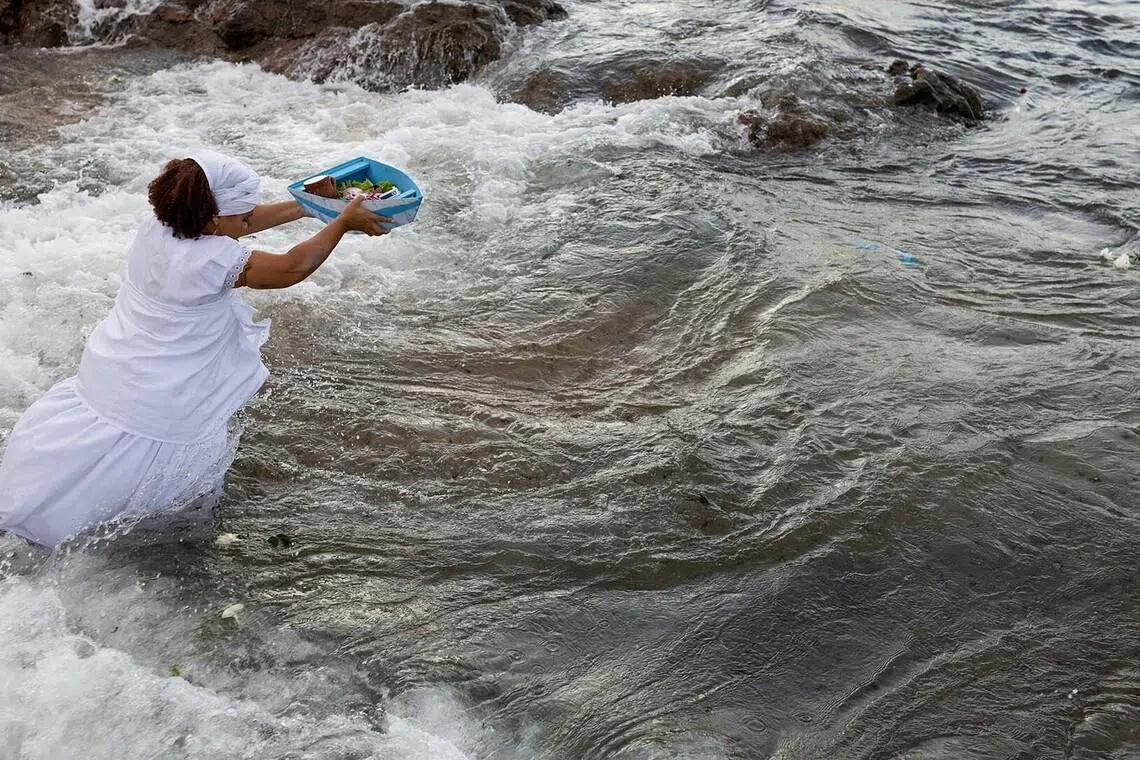 A worshipper honouring Lemanja, the Goddess of the Sea, in the syncretic Afro‑Brazilian religion Umbanda, during a traditional ceremony at Rio Vermelho beach in Salvador, Brazil, Feb 2, 2026. 
