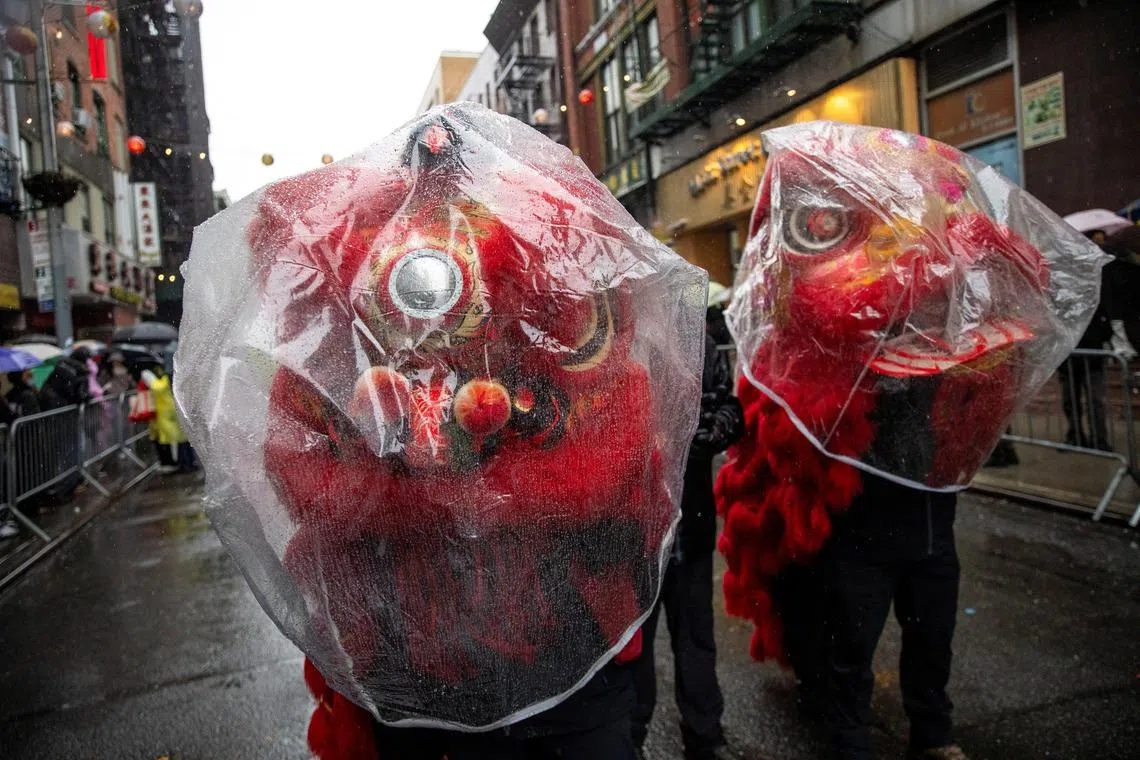 Revellers cover their customs from the rain while they take part in the Lunar New Year parade, celebrating the Year of the Snake, in the Chinatown neighborhood of New York City, U.S., February 16, 2025. REUTERS/Eduardo Munoz
