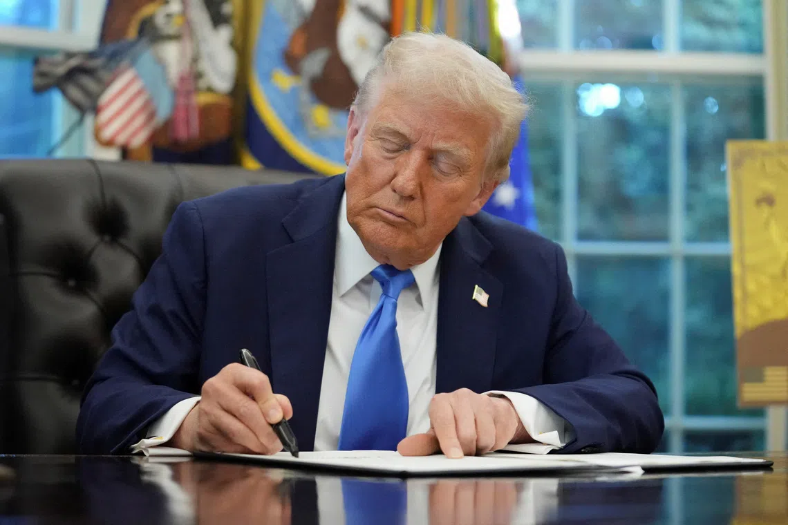 FILE PHOTO: U.S. President Donald Trump signs an executive order on gold card visa in the Oval Office at the White House in Washington, D.C., U.S., September 19, 2025. REUTERS/Ken Cedeno/File Photo