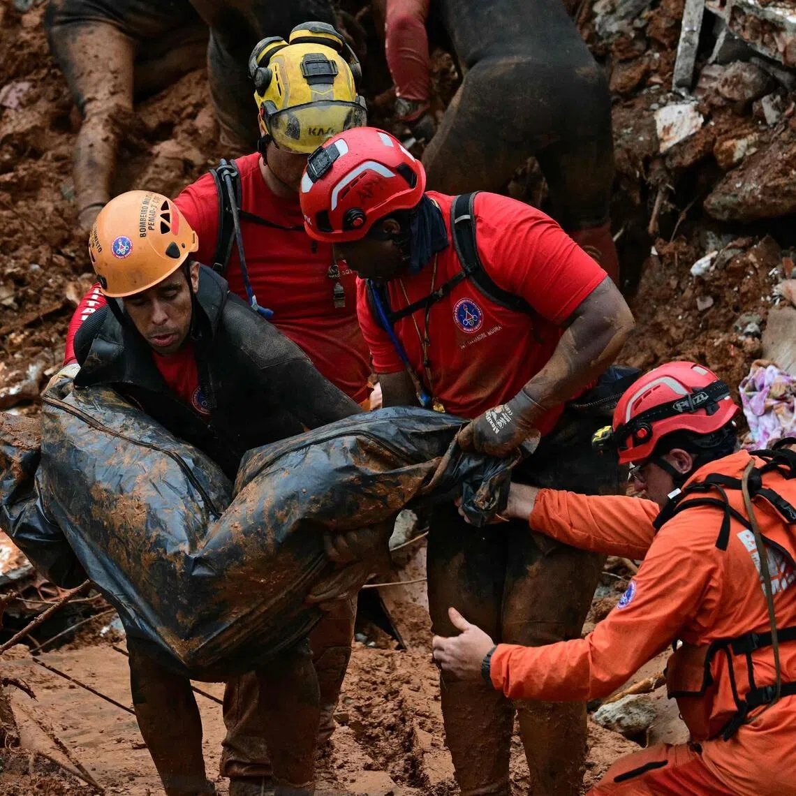 Firefighters carrying a body found in Juiz de Fora on Feb 24, after heavy rain caused a landslide. Rescuers in Brazil were still looking for 14 missing people on Feb 26.