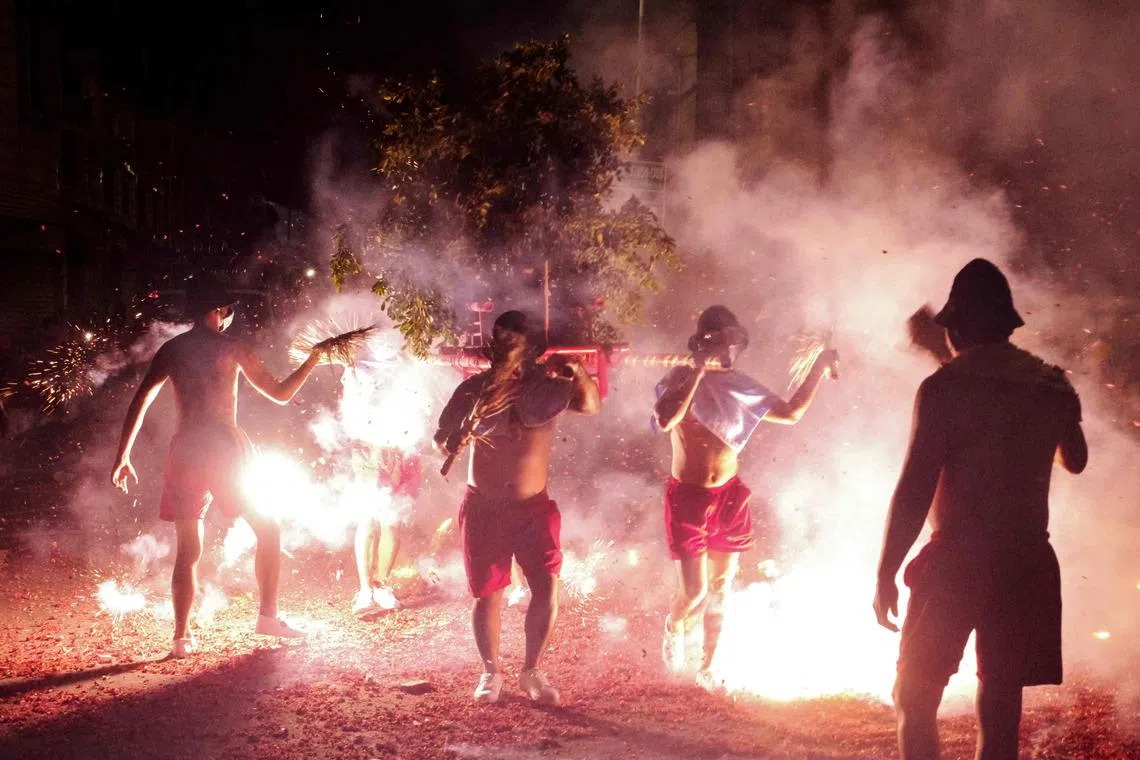 Workers carry a type of human-powered chair during the Bombing Master Han Dan festival celebrations on the last day of the Chinese New Year.