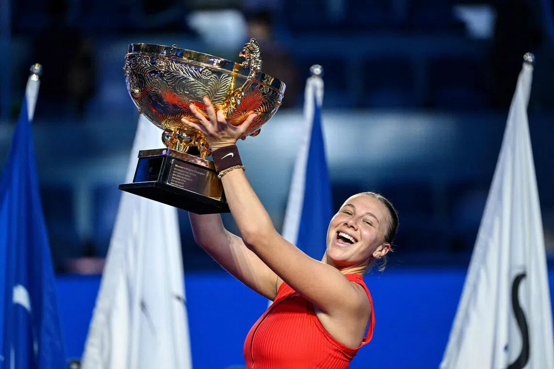 Amanda Anisimova celebrates with the trophy after winning the China Open in Beijing on Oct 5, 2025. 