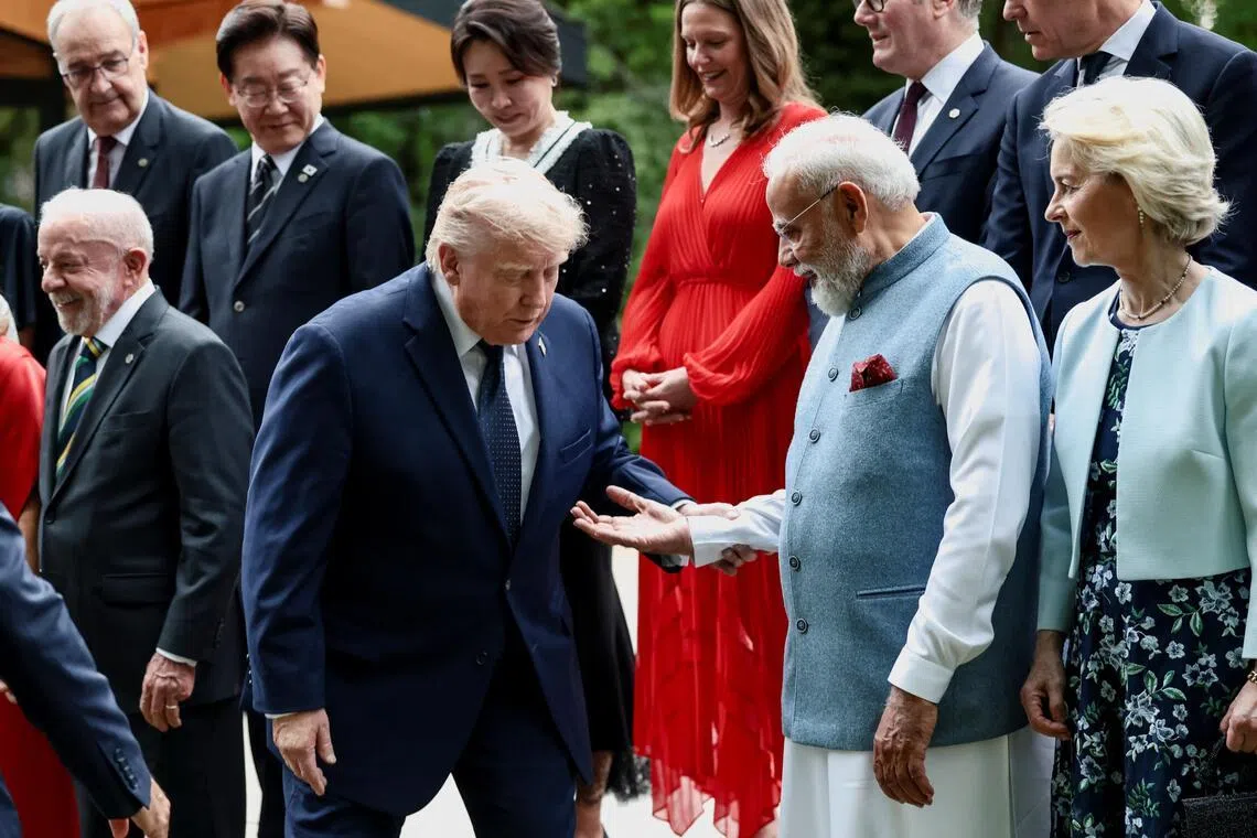 India's Prime Minister Narendra Modi offers a hand to US President Donald Trump (left) during a family photo at the G-7 summit, in Evian-les-Bains, France.