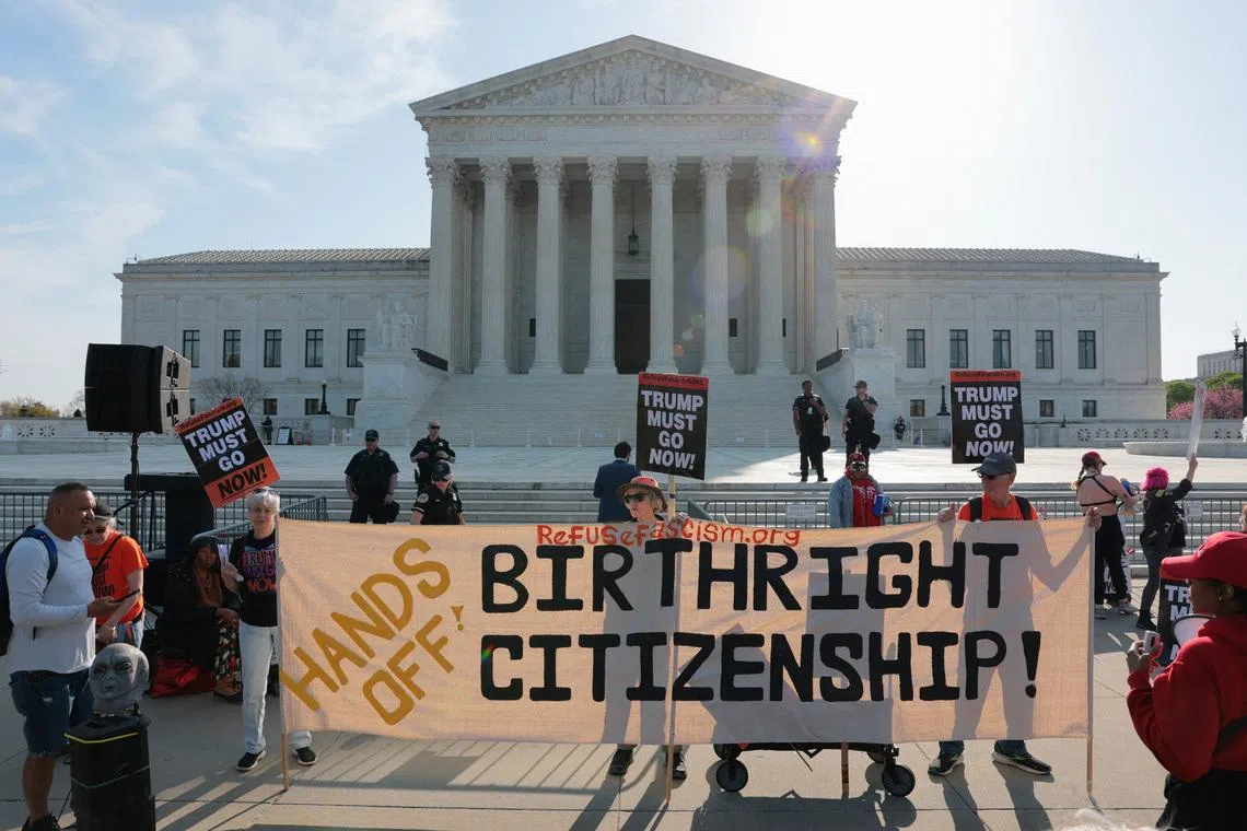 Demonstrators hold signs outside the U.S. Supreme Court building on the day the court is expected to hear oral arguments on the legality of the Trump administration's effort to limit birthright citizenship for the children of immigrants, in Washington, D.C., U.S., April 1, 2026. REUTERS/Kylie Cooper
