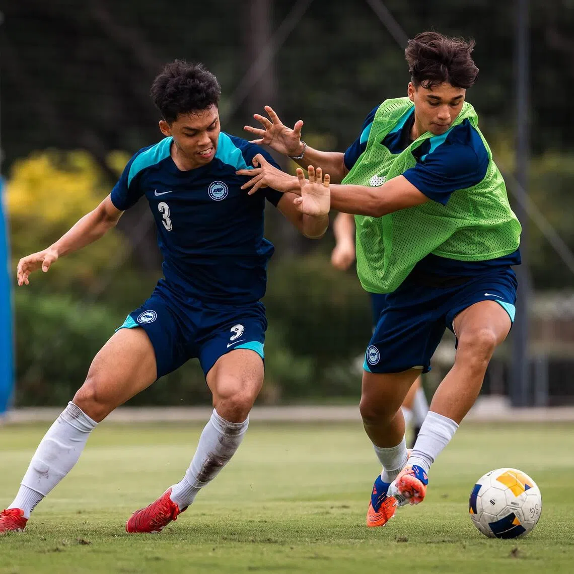 Singapore Under-22 footballers Fairuz Fazli (left) and Iryan Fandi tussling for the ball as they train in preparation for the SEA Games.