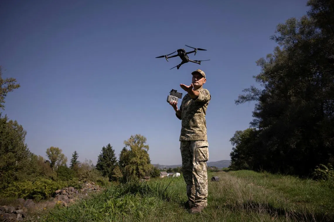 FILE PHOTO: A Ukrainian border guard launches a drone he uses to survey the border to Romania in Tyachiv, September 26, 2023.  REUTERS/Thomas Peter/File Photo