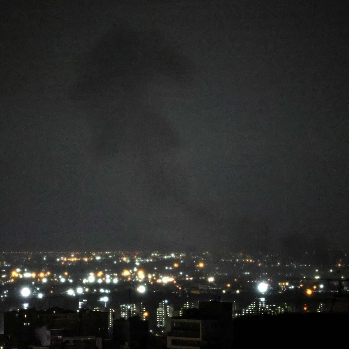 A plume of smoke rises from the site of a strike in Tehran early on March 28, 2026. 