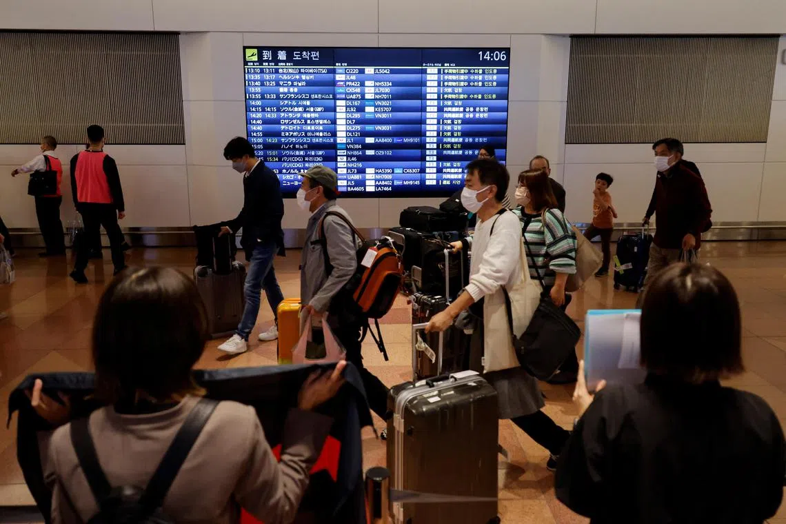 Passengers walk upon their arrival at the Haneda International Airport, on the first day Japan opened its doors to tourists after closing them for two-and-a-half years due to travel restrictions sparked by the outbreak of the coronavirus disease (COVID-19) pandemic, in Tokyo, Japan October 11, 2022.  REUTERS/Issei Kato
