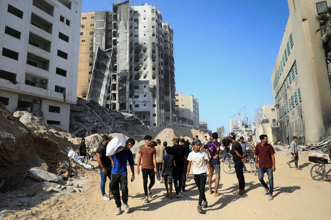 Palestinians gather as they inspect the damages after Israeli forces withdrew from a part of Gaza City, following a ground operation, amid the Israel-Hamas conflict, in Gaza City, July 12, 2024. REUTERS/Dawoud Abu Alkas