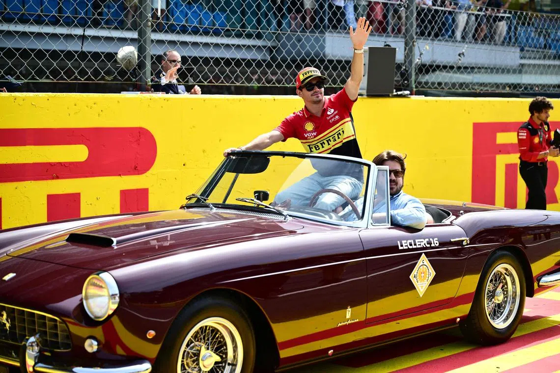 TOPSHOT - Ferrari's Monegasque driver Charles Leclerc (C) gestures during the drivers' parade prior to the Italian Formula One Grand Prix race at Autodromo Nazionale Monza circuit, in Monza on September 3, 2023. (Photo by Marco BERTORELLO / AFP)