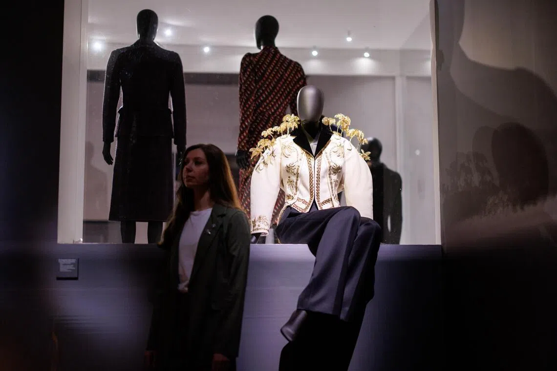 A gallery staff poses with creations by Schiaparelli at Schiaparelli: Fashion Becomes Art. The exhibition traces the arc of the designer’s namesake fashion house, all the way up to the tenure of its current creative director, Daniel Roseberry. 