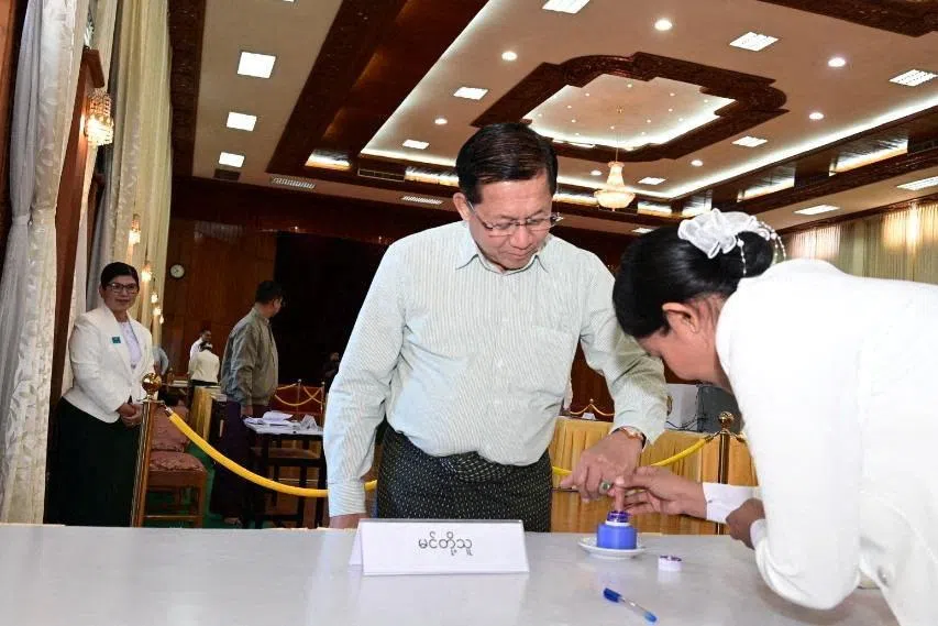 A polling official assists Myanmar's junta chief Min Aung Hlaing during voting at Zayarthiri polling station, on the day of the general elections in Naypyitaw, Myanmar, December 28, 2025. Myanmar Military Information Team/Handout via REUTERS