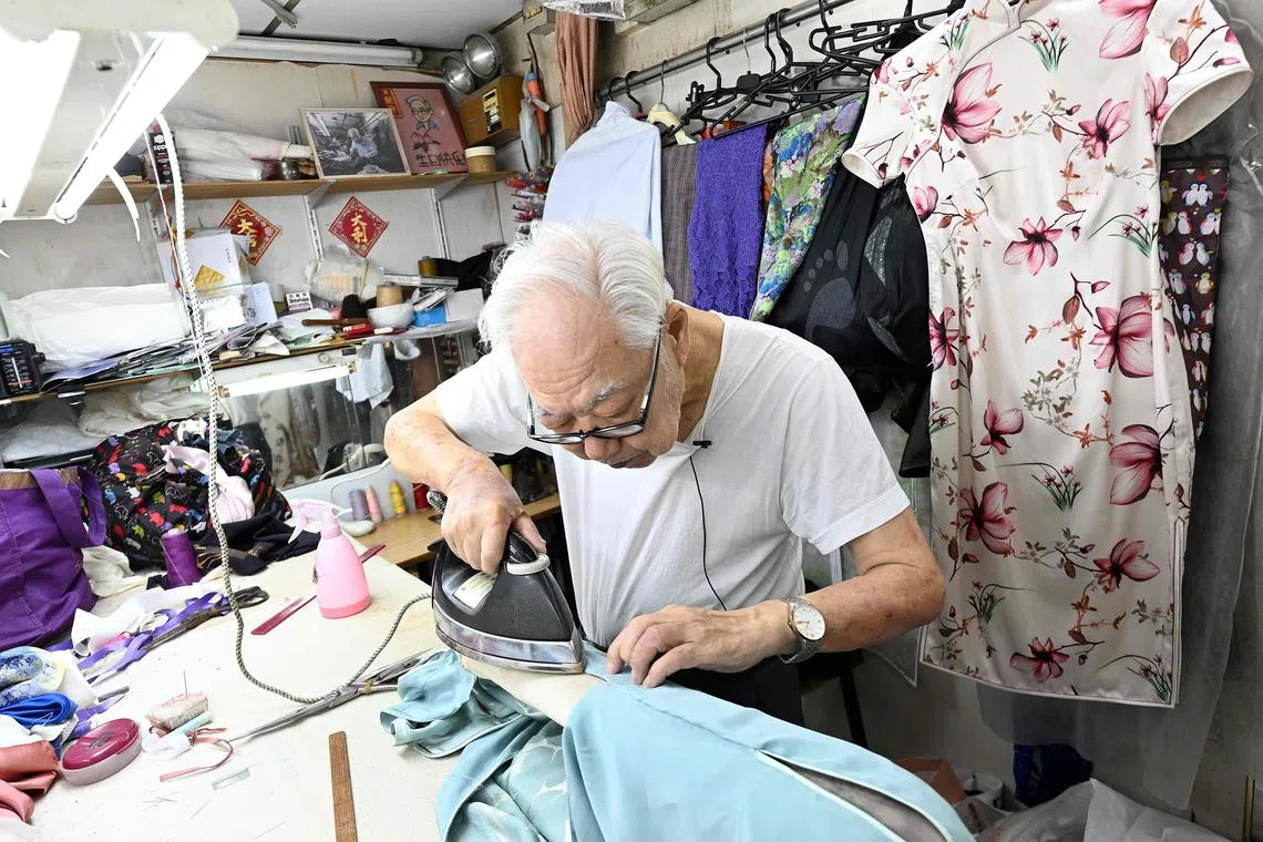 This photo taken on Sept 5 shows cheongsam master Yan Kar Man working in his small workshop in Kowloon, Hong Kong. 