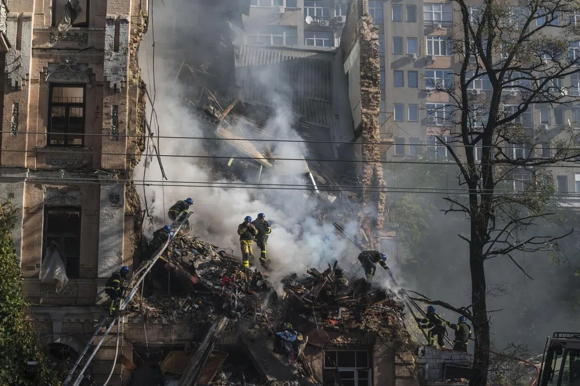 Rescue workers comb through the rubble of a residential building that was hit by a Russian drone in Kyiv, in October 2022.