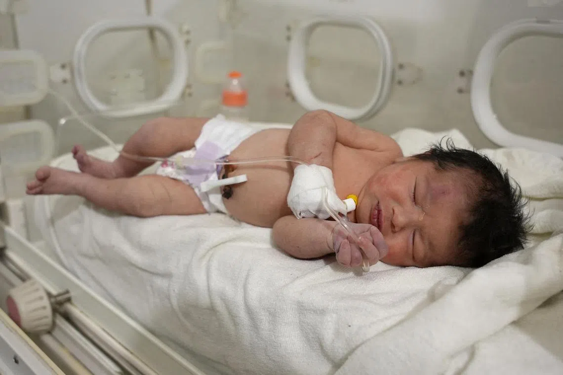 A newborn baby undergoes treatment after being pulled alive from the rubble of a quake-hit home in northern Syria, still attached by umbilical cord to her mother.