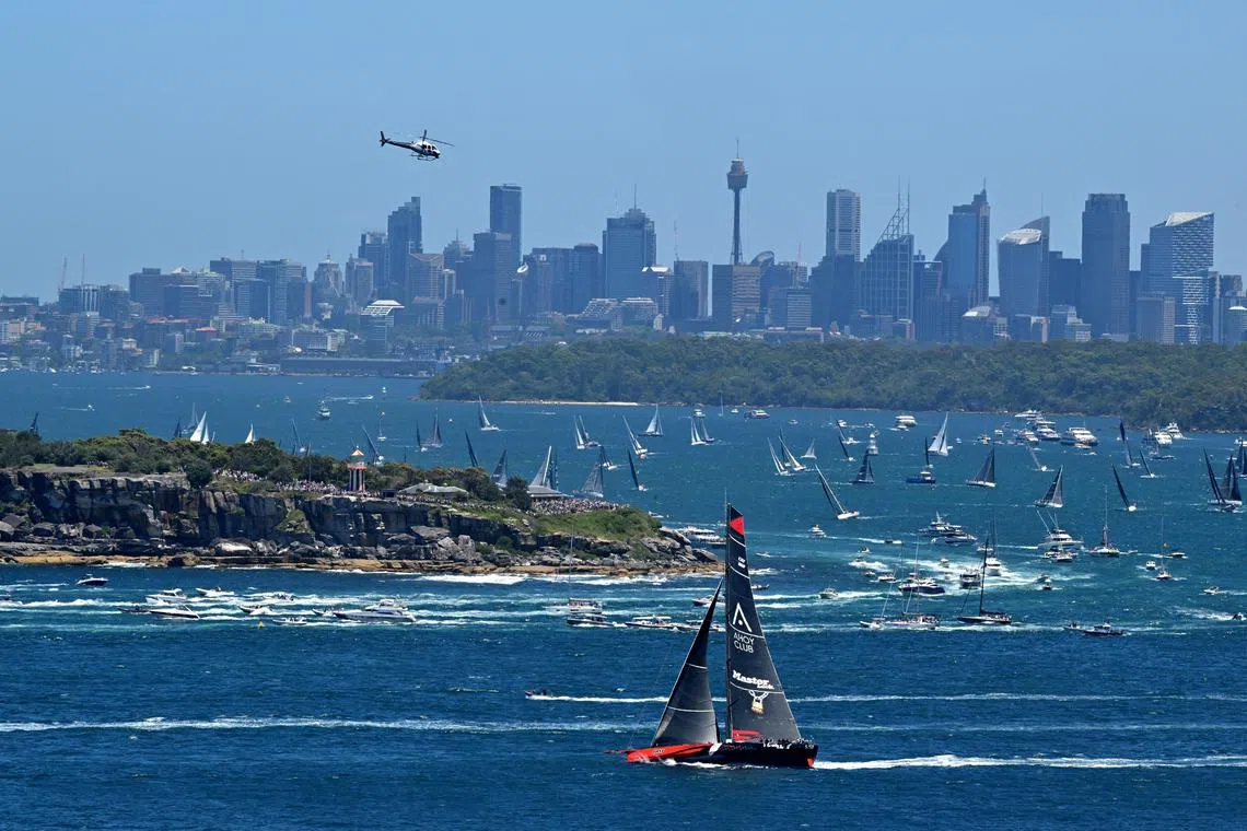 Race record holder Comanche, seen here sailing past South Head on Dec 26, is among 16 yachts to have retired from the initial fleet of 104 as the race experiences powerful winds.