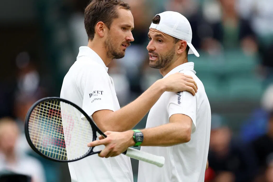 Tennis - Wimbledon - All England Lawn Tennis and Croquet Club, London, Britain - July 7, 2024 Bulgaria's Grigor Dimitrov with Russia's Daniil Medvedev after retiring injured from their fourth round match REUTERS/Hannah Mckay