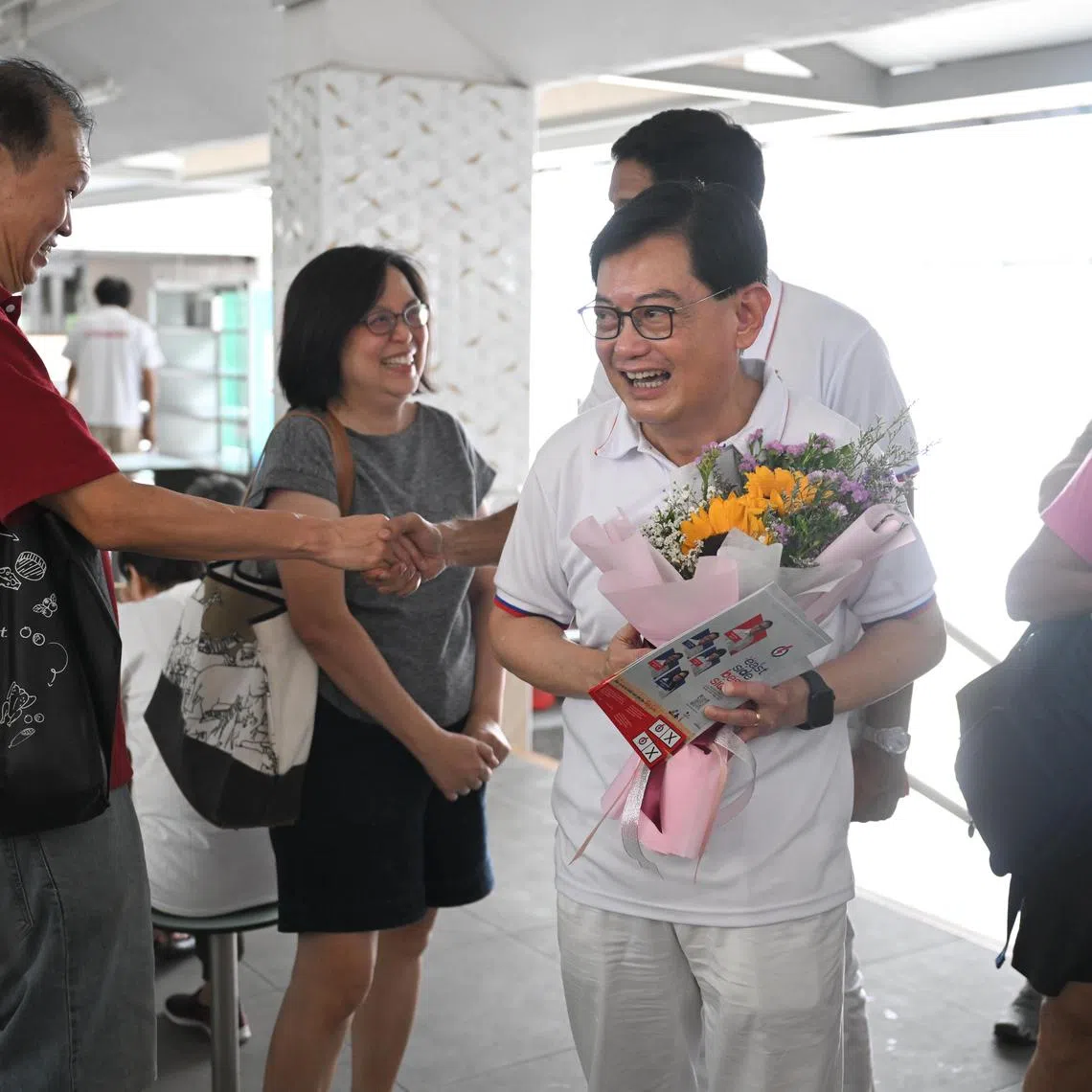 Deputy Prime Minister Heng Swee Keat with a bouquet given to him by a couple to thank him for all he had done, while on a walkabout in Bedok on May 1. 