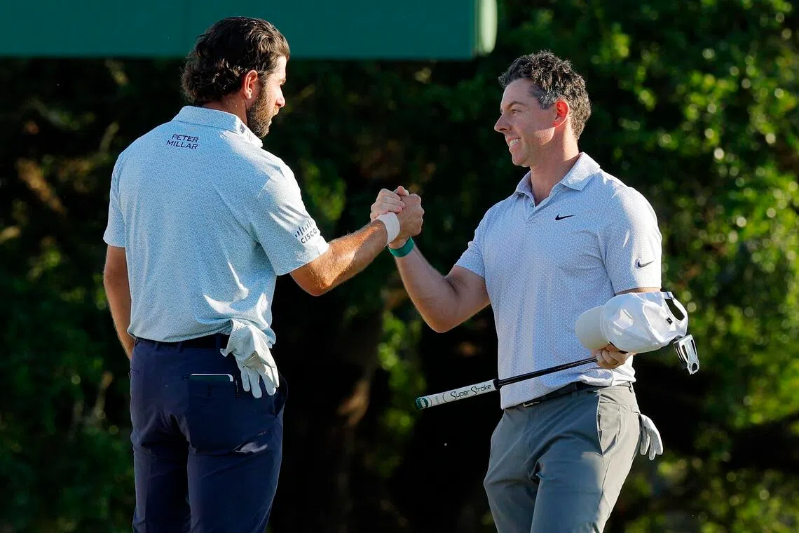 Third-round co-leaders Rory McIlroy of Northern Ireland and Cameron Young of the US shaking hands at Augusta National Golf Club in Augusta, Georgia, on the 18th hole during the second round on April 10.