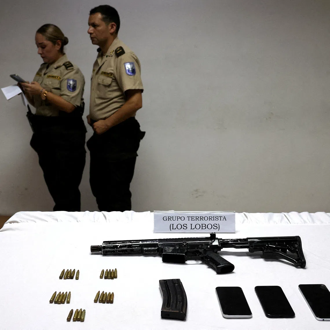 FILE PHOTO: A weapon is shown at a police station in the aftermath of a wave of violence that saw the storming of a TV station on-air and explosions around the nation, in Guayaquil, Ecuador, January 11, 2024. The sign reads 'Terrorist group Los Lobos'. REUTERS/Ivan Alvarado/File Photo