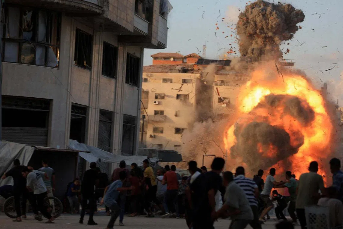 Smoke and flames rising while a residential building collapses after an Israeli air strike, in Gaza City, Sept 7, 2025. 