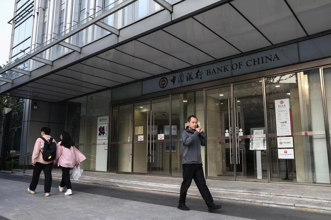 epa11622006 People walk beside a bank of China in Beijing, China, 24 September 2024. China's central bank will reduce the interest rate of seven-day reverse repurchases from 1.7 percent to 1.5 percent and cut the reserve requirement ratio by 0.5 percentage points in the near future, freeing up about 1 trillion yuan (about 127.83 billion euros) for new lending, according to People’s Bank of China governor Pan Gongsheng on Tuesday.  EPA-EFE/WU HAO