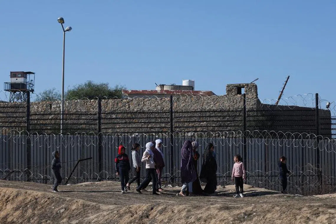 Displaced Palestinians, who fled their houses due to Israeli strikes, walk as they seek shelter at the border with Egypt, in Rafah in the southern Gaza Strip, January 7, 2024. REUTERS/Ibraheem Abu Mustafa