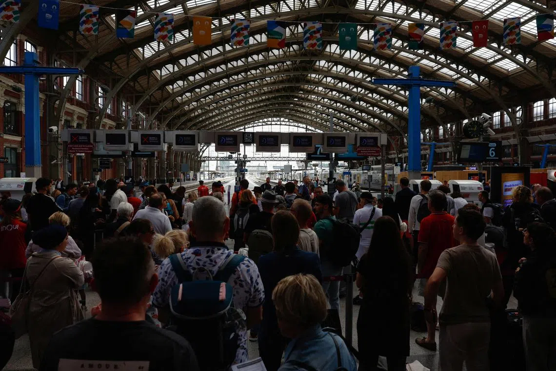 FILE PHOTO: People wait at Gare de Lille-Flandres train station after a series of coordinated actions against France's high-speed train network that brought major disruption, hours ahead of the Paris 2024 Olympics opening ceremony, in Lille, France, July 26, 2024. REUTERS/Evelyn Hockstein/File Photo