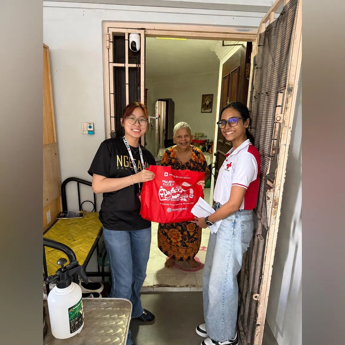 (Left) Lim Jing and Sanchari Das (right) with a beneficiary. In all, 570 volunteers were involved in the packing and distribution of the household items.