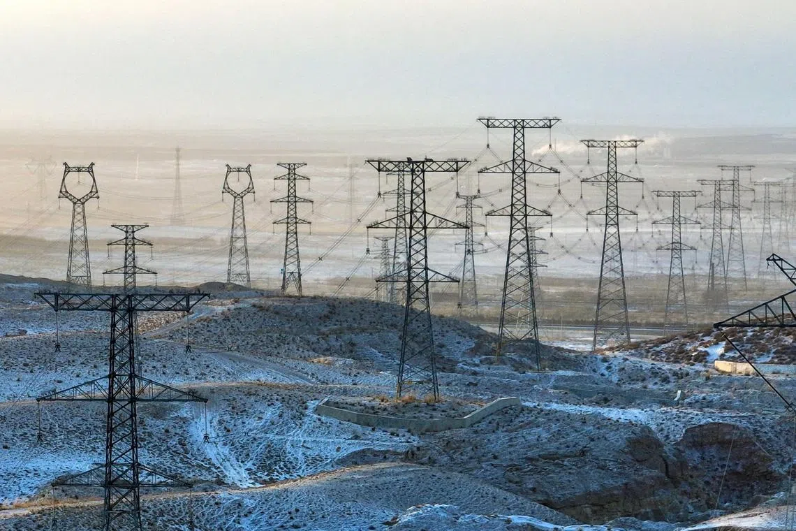 TOPSHOT - This aerial photo taken on January 21, 2024 shows electricity transmission towers in the snow-covered Gobi desert in Yinchuan, in China’s northern Ningxia region. (Photo by AFP) / China OUT