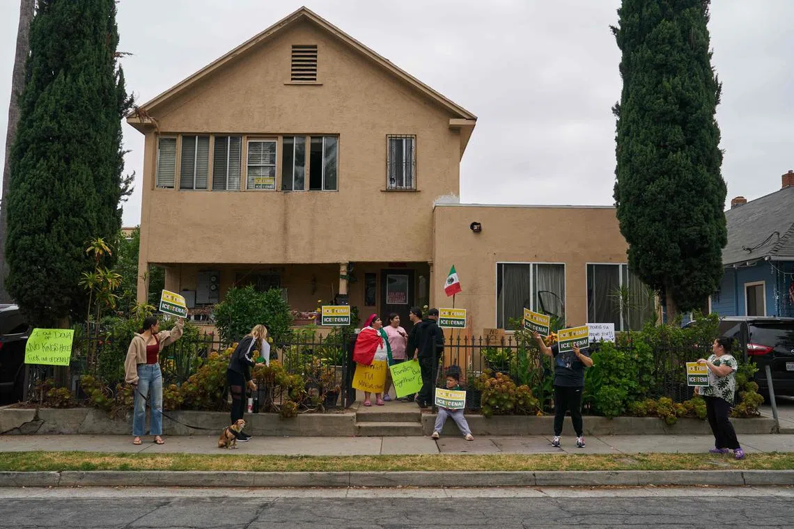 People demonstrate against federal immigration enforcement outside a home in Pasadena, California, after their neighbours were taken by Immigration and Customs Enforcement on the morning of June 21, 2025.