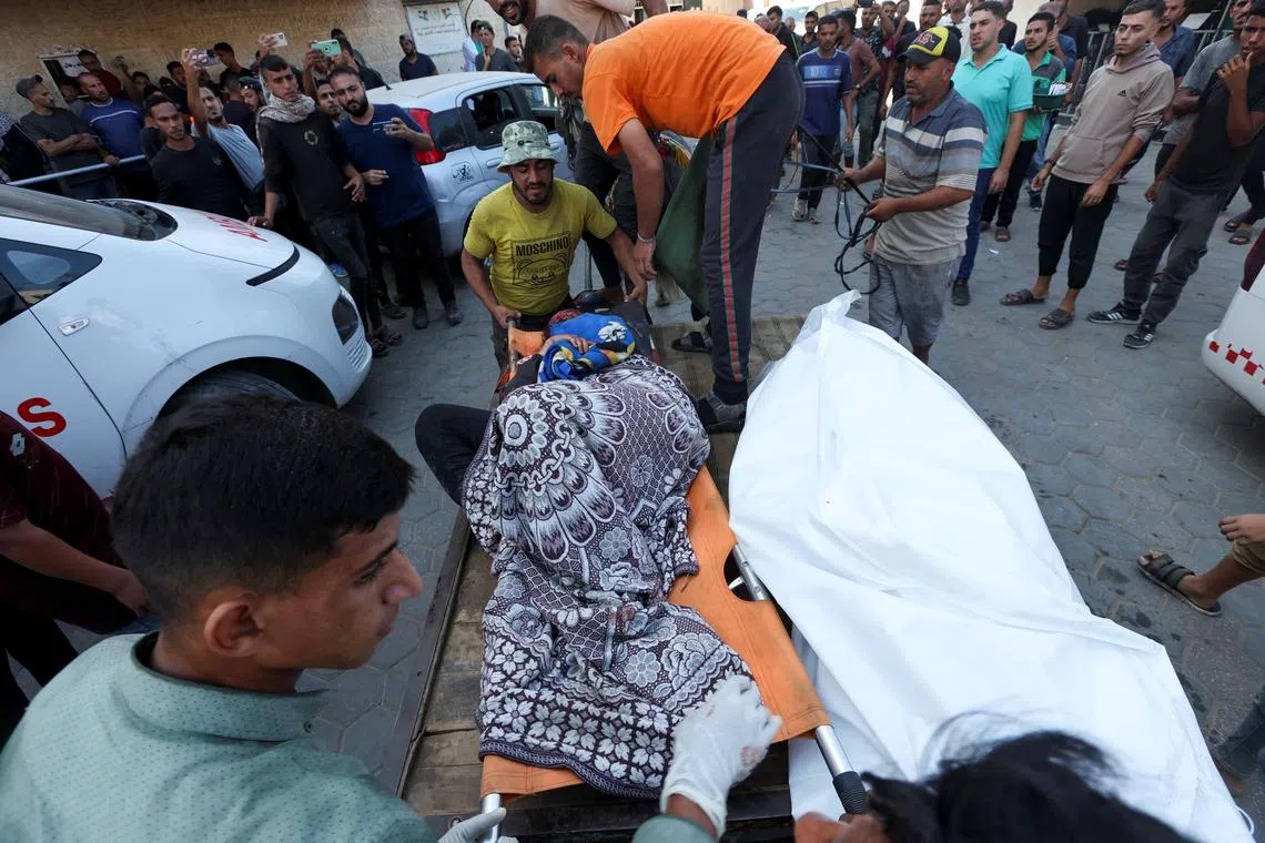 Palestinians carry casualties at Al-Aqsa Martyrs Hospital, in the aftermath of an Israeli strike on a school sheltering displaced people, amid the Israel-Hamas conflict, in Deir Al-Balah, central Gaza Strip, October 10, 2024. REUTERS/Ramadan Abed