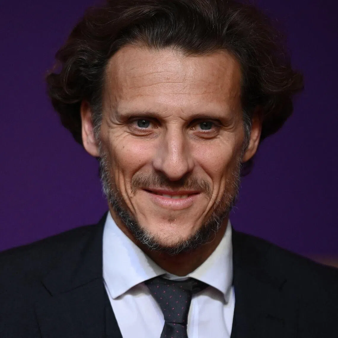 (FILES) Former Uruguayan footballer Diego Forlan arrives for the draw for the 2022 World Cup in Qatar at the Doha Exhibition and Convention Center on April 1, 2022. The Uruguayan Football Association (AUF) is on July 13, 2026, on the verge of finalising an agreement with Diego Forlan for him to take charge of the Under-20s and act as interim manager of the senior team, following its failure at the World Cup with Marcelo Bielsa in charge. The former striker is the third-highest goalscorer in La Celeste’s history, behind Luis Suarez and Edinson Cavani. Winner of the Ballon d’Or in South Africa, the forward was crowned champion of the 2011 Copa America in Argentina, the senior national team’s most recent major achievement. (Photo by FRANCK FIFE / AFP)