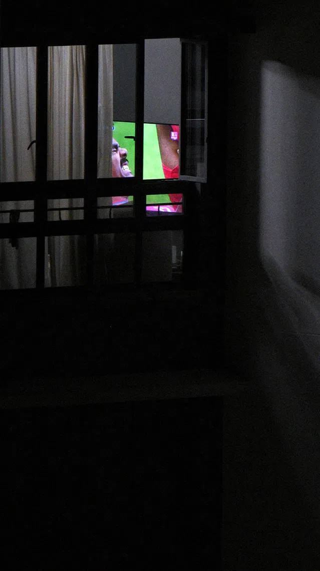 (Pls note: For pixdesk HIF, only used for that purpose) A Dawson Road resident watches the World Cup group stage match of Congo and Portugal on a television in the early hours of June 18, 2026. On screen, Renato Veiga of Portugal winces.