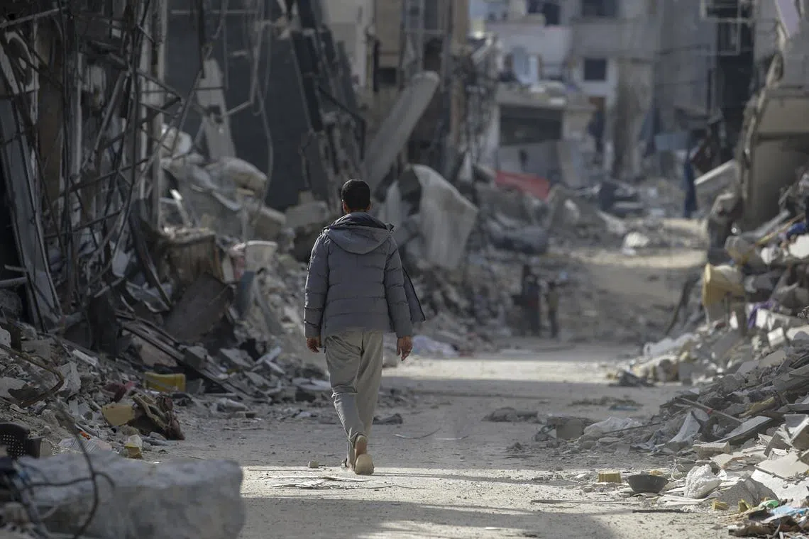 A Palestinian man walking past destroyed buildings in Khan Younis, after the Israeli military pulled out troops from the southern Gaza Strip, on April 30, 2024.