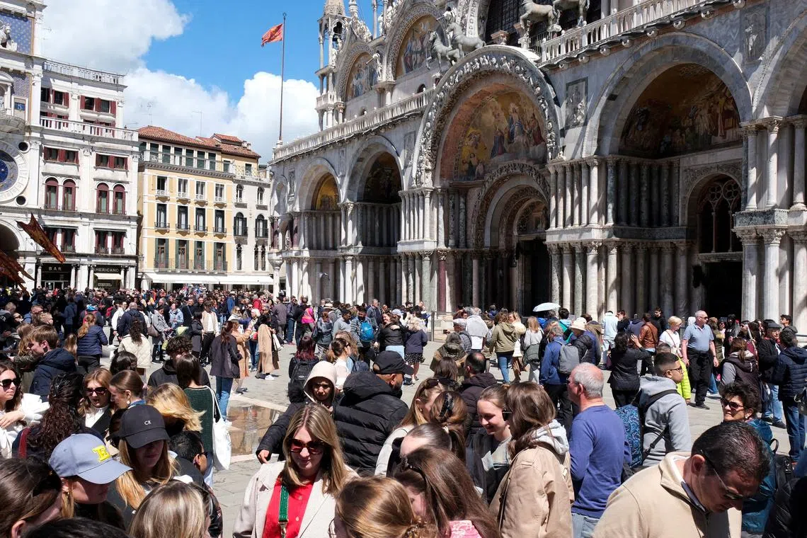 FILE PHOTO: Tourists walk in St Mark's Square on the day Venice municipality introduces a new fee for day trippers in a move to preserve the lagoon city often crammed with tourists in Venice, Italy, April 25, 2024. REUTERS/Manuel Silvestri/File Photo