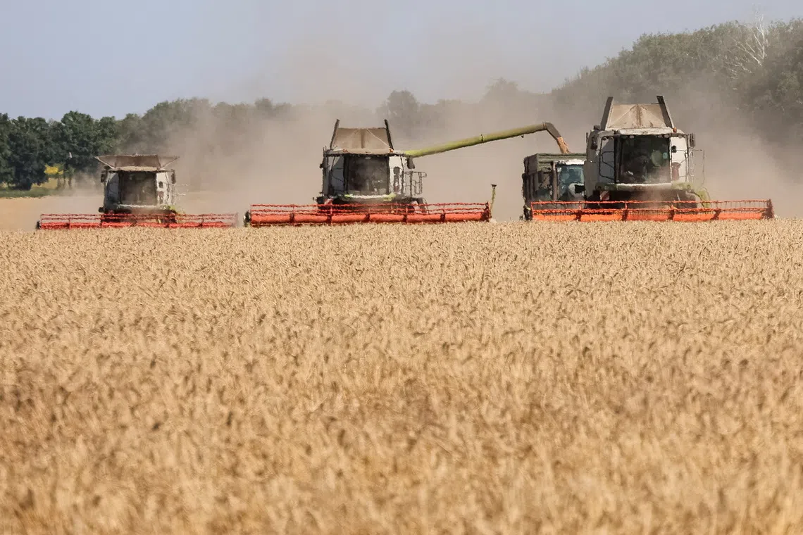 Combines harvest wheat in a field, amid Russia's attack on Ukraine, in Kharkiv region, Ukraine August 3, 2026. REUTERS/Vyacheslav Madiyevskyy