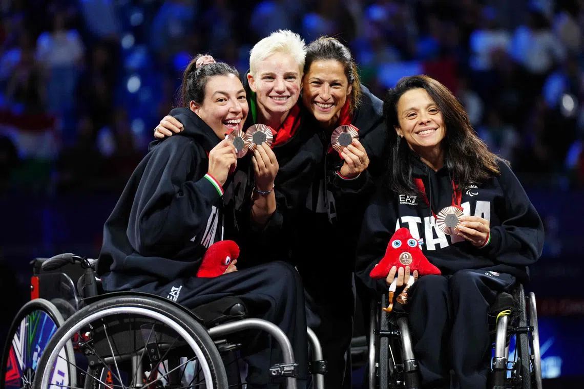 From left: Italy's Andreea Mogos, Bebe Vio, Loredana Trigilia and Rossana Pasquino pose on the podium after winning bronze in the team fencing at the Paris Paralympics.